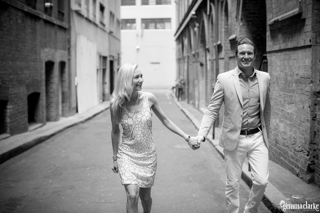 A smiling couple walking hand in hand down an alley way - Urban Sydney Portraits