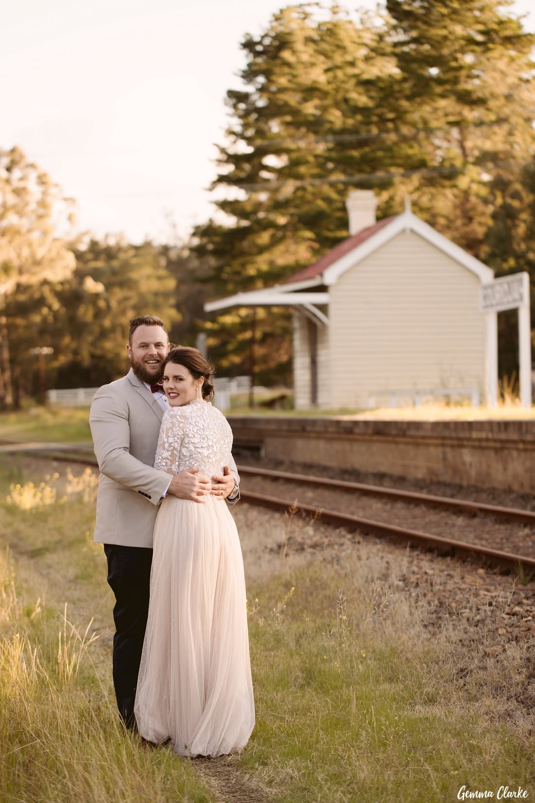 Bride and Groom cuddle by the old railway station near their Buxton wedding location