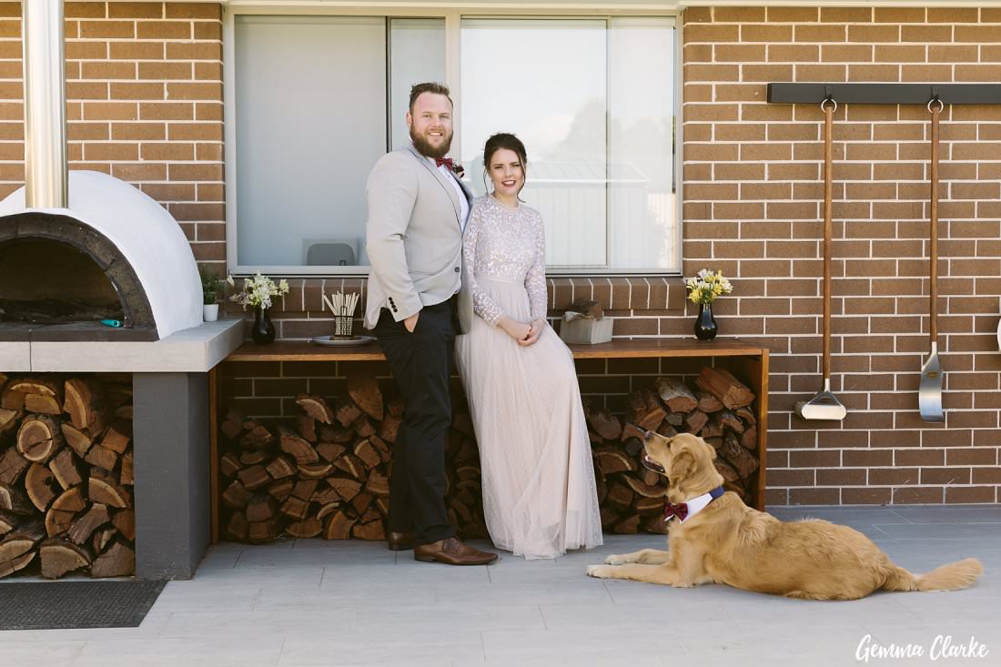 With their furbaby Barnaby and their second baby, their wood fire oven they made! A great addition for their backyard Buxton Wedding