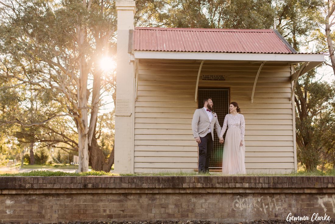 The sun was at the perfect angle to peak through the big tree at the back while the couple stand in front of the old railway station near their Buxton Wedding location